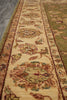 Load image into Gallery viewer, A close-up view of an ornate area rug with a traditional floral pattern in beige, olive green, brown, and muted blue tones.