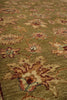Load image into Gallery viewer, A close-up view of a traditional patterned area rug with a muted olive green base, featuring large floral motifs in beige, brown, and dusty pink with small accents of blue and red.