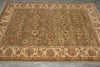 Load image into Gallery viewer, An oriental area rug with a sage green field, beige borders, and intricate floral motifs in muted red, brown, and blue tones, laid out on a gray tiled floor.