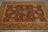 Load image into Gallery viewer, A rectangular traditional area rug with an intricate floral and medallion pattern, featuring a dark brown center field and a warm beige border, laid flat on a gray tiled floor.
