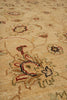Load image into Gallery viewer, Close-up of a beige area rug with a traditional floral and vine pattern in muted red, green, and dark blue accents.