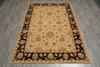 Load image into Gallery viewer, A rectangular area rug with a traditional floral pattern, featuring a beige center field, a black border, and a tan outer border, shown on a gray wood-look floor.