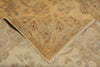 Load image into Gallery viewer, A close-up of a folded area rug showing its intricate traditional floral pattern in beige, tan, muted blue-gray, and small red accents.