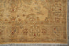 Load image into Gallery viewer, A close-up of an antique-style area rug with a warm beige and ochre base, featuring faded floral motifs in muted blue-gray and small red accents.