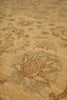 Load image into Gallery viewer, A close-up view of a traditional patterned rug in warm beige and tan tones with muted blue-gray and small red accents.