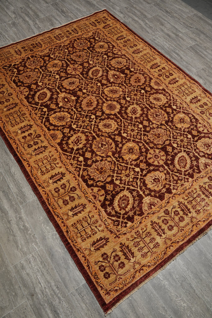 An oriental-style area rug with an intricate floral and geometric pattern, shown laid out on a gray wood-look floor.