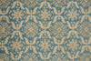 Load image into Gallery viewer, A close-up of a patterned textile or rug featuring a repeating damask-style floral motif in blue and warm beige.