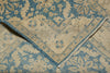 Load image into Gallery viewer, A close-up of a folded area rug showing its intricate traditional pattern in dusty blue and warm beige/cream tones.