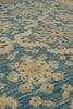 Load image into Gallery viewer, A close-up of a woven rug with an intricate floral and medallion pattern in muted blue and warm beige.