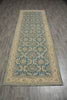 Load image into Gallery viewer, A long rectangular area rug with a traditional floral and geometric pattern in muted blue and beige, laid out on a gray wood-look floor.