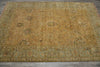 Load image into Gallery viewer, A rectangular vintage-style area rug with a distressed mustard yellow center and a muted sage green border, laid flat on a gray tiled floor.