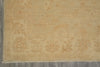 Load image into Gallery viewer, A close-up of a light beige area rug with a subtle faded floral pattern and fringed edge, laid on a gray tiled floor.