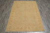 Load image into Gallery viewer, A rectangular area rug in a warm sandy beige color with a subtle faded traditional floral pattern, shown flat on a gray wood-look floor.