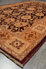 Load image into Gallery viewer, An ornate traditional area rug with a complex floral and geometric pattern in shades of dark brown, rust orange, and beige, shown laid out on a gray tiled floor.
