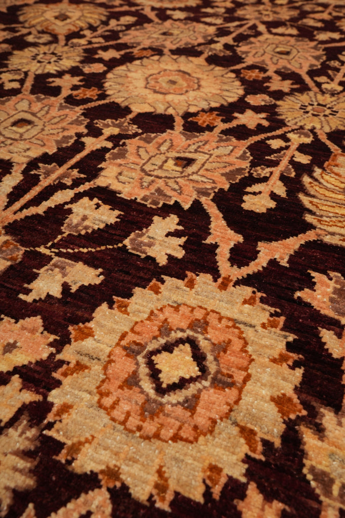 Close-up of a traditional patterned rug with a dark brown base and cream, tan, and rust floral medallions.