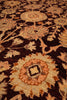 Load image into Gallery viewer, Close-up of a traditional patterned rug with a dark brown base and cream, tan, and rust floral medallions.