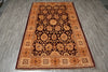 Load image into Gallery viewer, A rectangular traditional area rug with an intricate floral and medallion pattern, laid flat on a gray wood-look floor. The rug features a dark brown center, a warm tan and orange inner border, and a deep red outer border.