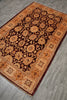Load image into Gallery viewer, An oriental-style area rug with an intricate floral pattern, shown laid out on a gray wood-look floor. The rug features a dark brown center field with beige and orange floral motifs, surrounded by a warm tan border with red accents.