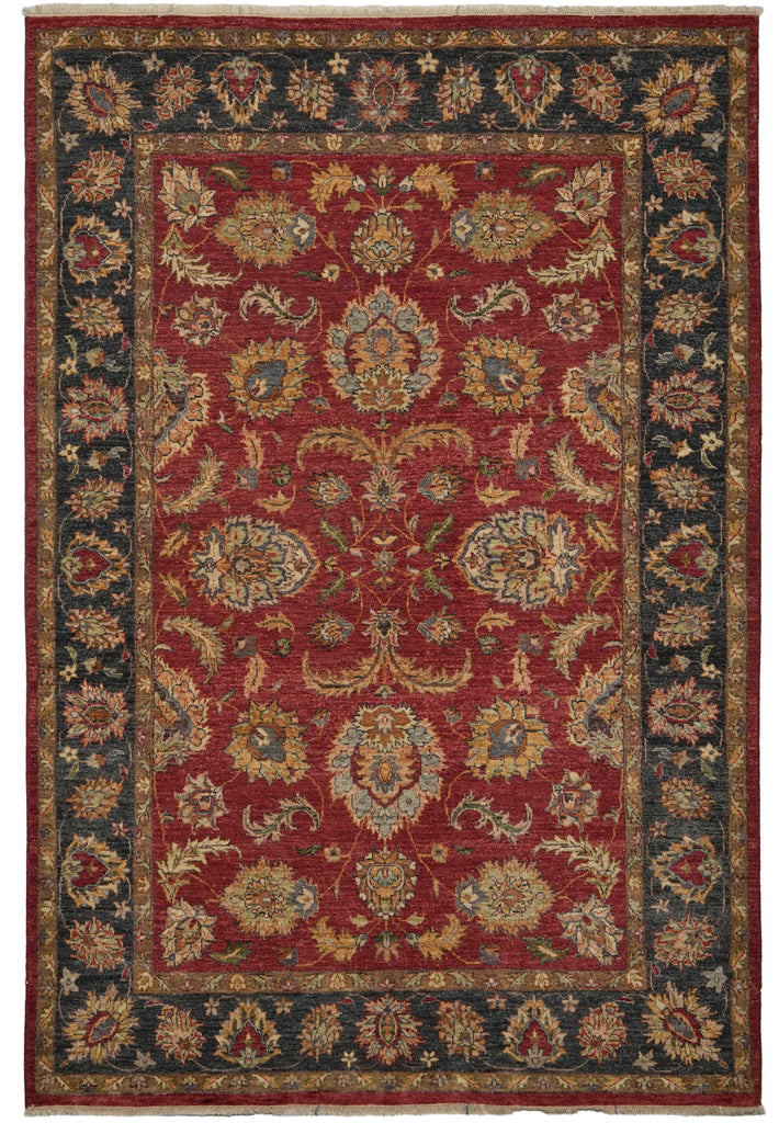 An antique-style oriental area rug with a deep red central field, featuring intricate floral and medallion motifs in beige, gold, and muted blue, surrounded by a dark navy blue border.