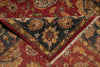 Load image into Gallery viewer, A close-up of an ornate patterned rug showing a folded corner that reveals a dark navy blue field with floral motifs in gold, red, and beige, layered over a larger red and gold patterned section.