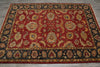 Load image into Gallery viewer, A traditional oriental area rug with a deep red field, featuring intricate floral and medallion motifs in gold, beige, and blue, surrounded by a dark navy border with gold detailing, laid out on a gray tiled floor.