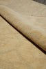 Load image into Gallery viewer, Close-up of a beige woven rug with a rolled corner showing the texture and pile, on a neutral surface.