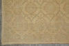 Load image into Gallery viewer, A close-up of a beige area rug with a faded traditional medallion pattern in muted gray-green tones, showing the woven texture and fringe edge.