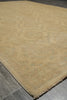 Load image into Gallery viewer, A close-up view of a beige area rug with a subtle distressed medallion pattern, shown on a gray tiled floor.