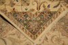 Load image into Gallery viewer, A close-up of a traditional patterned rug showing its corner detail, featuring a beige base with a green central field and intricate floral motifs in red, blue, and yellow.
