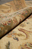 Load image into Gallery viewer, A close-up of a rolled section of a traditional patterned area rug showing its beige base and multicolored floral and paisley motifs.