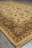 Load image into Gallery viewer, A traditional oriental-style area rug with a beige base and an intricate floral pattern in muted green, rust red, and blue, shown laid out on a gray tiled floor.