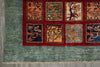 Load image into Gallery viewer, A close-up of a traditional patterned rug showing a teal-blue field, a wide red border, and eight rectangular panels with floral and geometric motifs in beige, green, and blue.