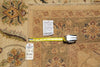 Load image into Gallery viewer, A close-up of a patterned area rug in beige and brown tones, laid flat with a yellow tape measure and two inventory tags placed on top to show dimensions and condition.