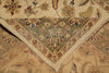 Load image into Gallery viewer, A close-up of a traditional patterned rug showing the corner and fringe detail, with a beige base and floral motifs in muted green, brown, and red.