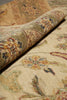Load image into Gallery viewer, A close-up of a traditional oriental-style area rug with a rolled section showing the pattern and pile texture. The rug features an intricate floral and vine motif in muted tones of beige, olive green, mustard yellow, and dusty red.