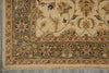 Load image into Gallery viewer, A close-up of a traditional oriental rug showing its corner, featuring a beige field with a green border and floral motifs in muted red, blue, and brown.