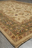 Load image into Gallery viewer, A traditional oriental area rug with a beige and olive green base, featuring floral motifs and a detailed border, laid out on a gray wood floor.