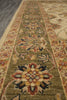 Load image into Gallery viewer, A close-up view of a traditional oriental-style runner rug with a beige and olive green base, featuring intricate floral motifs in red, blue, and yellow.