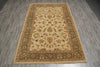 Load image into Gallery viewer, A rectangular traditional area rug with an ornate floral and vine pattern, laid flat on a gray wood-look floor. The rug features a warm beige center, a dark olive green inner border, and a light tan outer border with multicolored floral motifs.