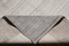 Load image into Gallery viewer, A close-up of a folded area rug showing its textured, heathered gray and beige woven pattern.
