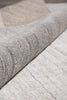 Load image into Gallery viewer, Close-up of a light gray wool felt rug with a rolled section showing the dense, textured pile.