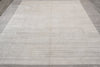 Load image into Gallery viewer, A large rectangular area rug with a textured, heathered light gray and beige surface, shown laid out on a dark wood floor.