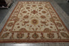 Load image into Gallery viewer, An oriental area rug with a traditional floral and medallion pattern, featuring a cream background with rust red, gold, and green accents, laid out on a gray wood floor.