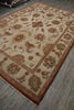 Load image into Gallery viewer, A rectangular area rug with an ornate floral and scroll pattern, shown laid out on a gray wood-look floor. The rug has a warm beige center field, a rust red border, and multicolored details in green, blue, and brown.
