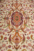 Load image into Gallery viewer, Detailed pattern view of the Persian Tabriz rug's central medallion with symmetrical floral and paisley design in coral, purple, and green on an ivory ground