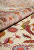 Load image into Gallery viewer, Persian Tabriz rug partially rolled to show plush hand-knotted pile thickness alongside the ivory field's floral pattern