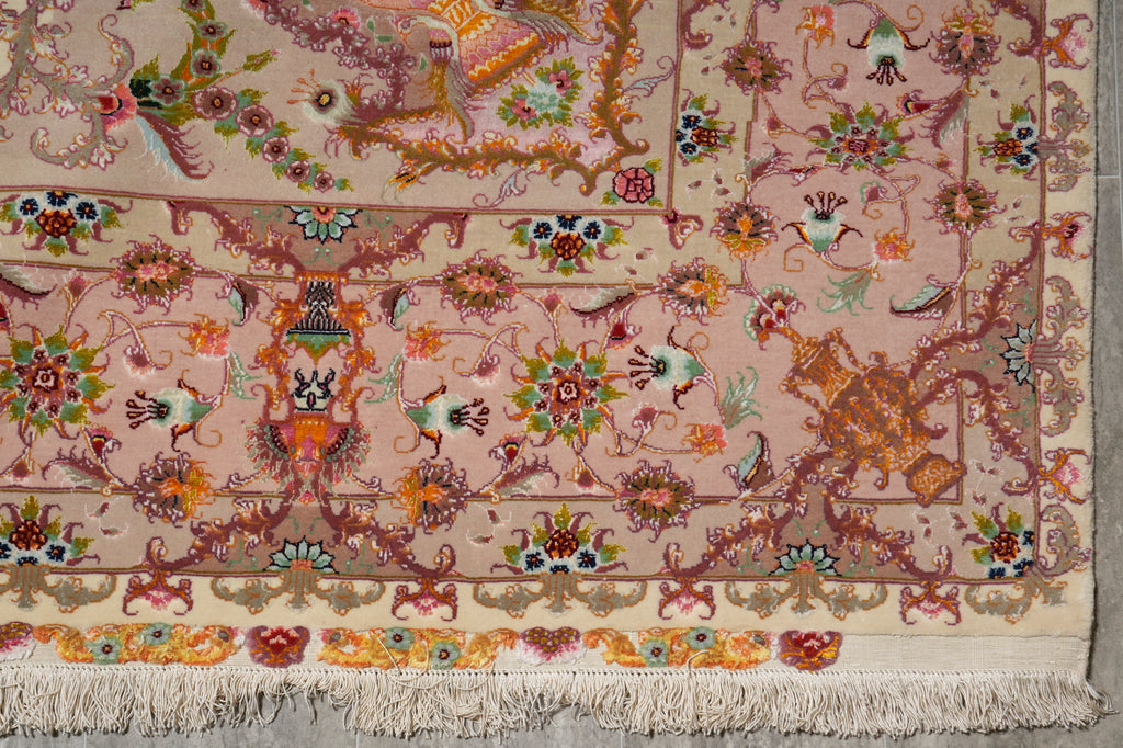 Border and corner detail of the Persian Tabriz rug with pink field, floral vine motifs, and ivory guard band above the fringe