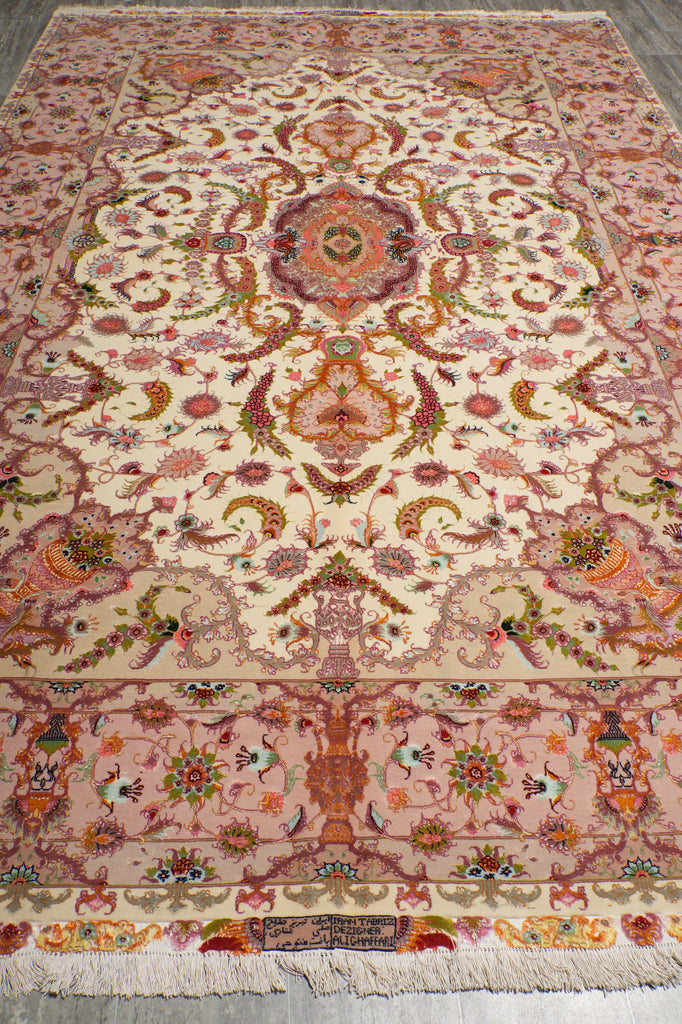 6.7 x 10.3 Persian Tabriz rug end detail with central medallion, pink floral border, and hand-knotted fringe with woven signature panel
