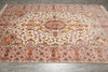 Load image into Gallery viewer, Wide angle view of the 6.7 x 10.3 Persian Tabriz rug on the floor, highlighting the medallion center and floral border in pink, beige, and orange