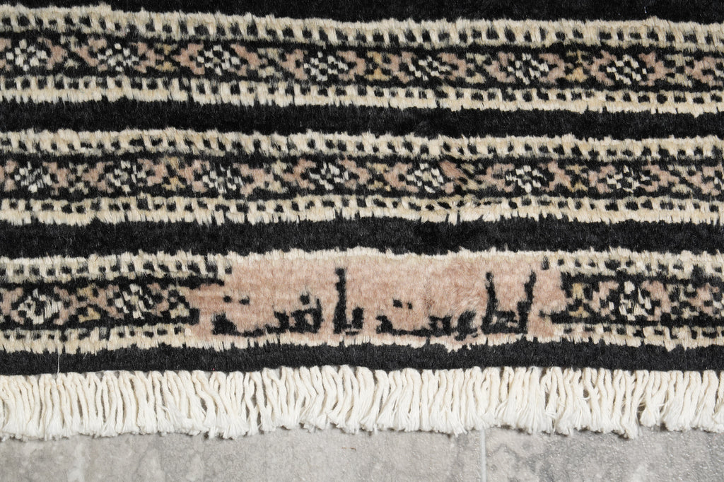 Close-up of a textured rug with geometric pattern on a gray surface